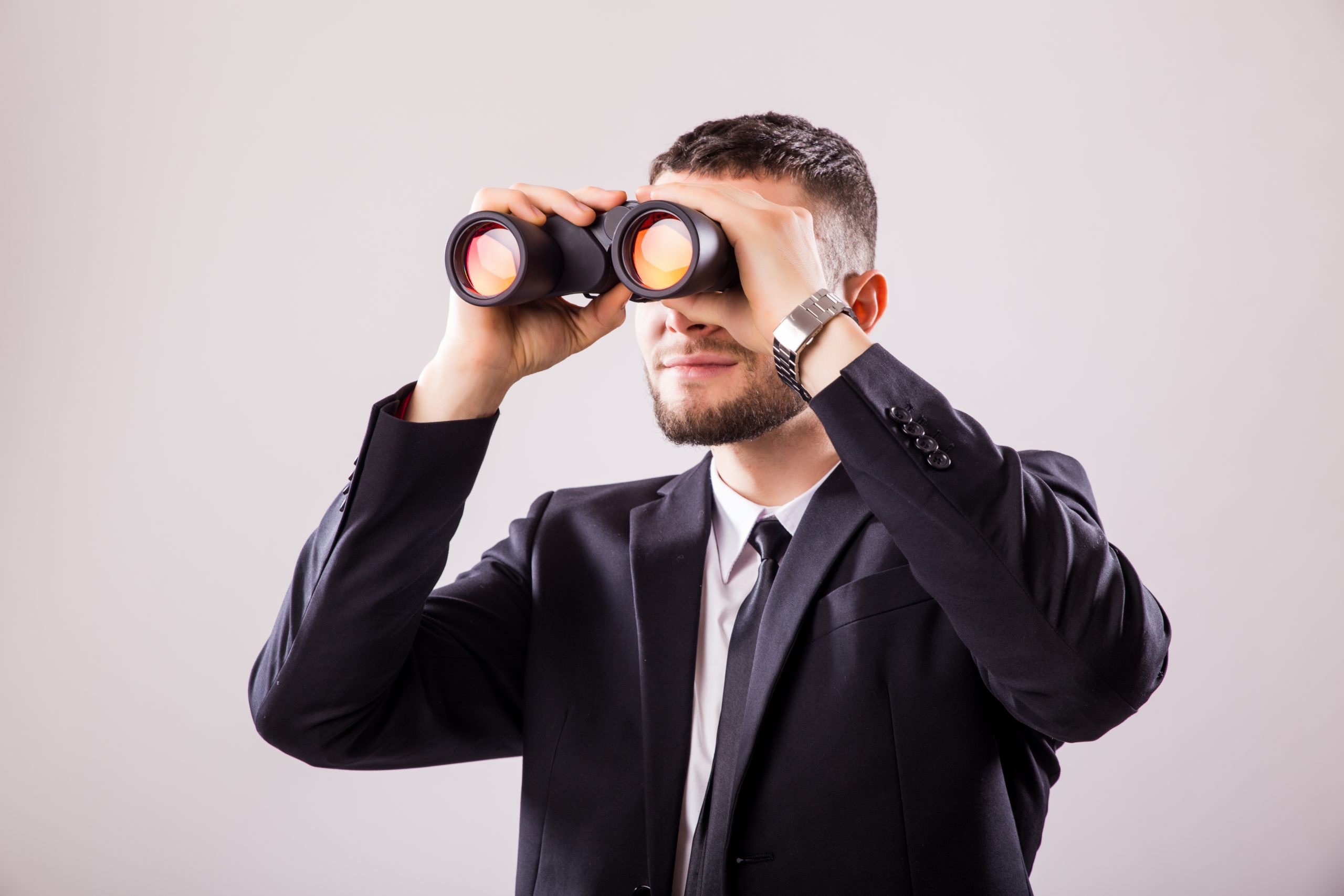 Businessman Looking Through Binoculars Isolated On White Background